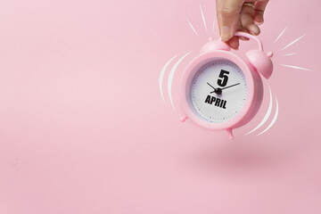April 5th. Day 5 of month, Calendar date. The morning alarm clock jumping up from the bell with...