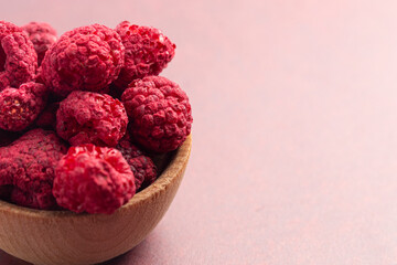 A Bowl of Freeze Dried Raspberries on a Rustic Red Table