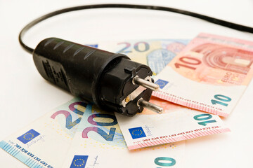 Power plug on euro banknotes. Cost of electricity and expensive energy concepts. Increasing consumption, energy crisis. Inflation. Price level are getting more expensive annually.