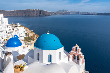 Famous blue domed church in Oia, Santorini, offering a beautiful panorama over the sea and the caldera, Greece