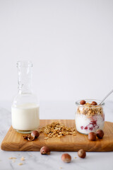 Cooking granola with yogurt and red berries in a glass jar