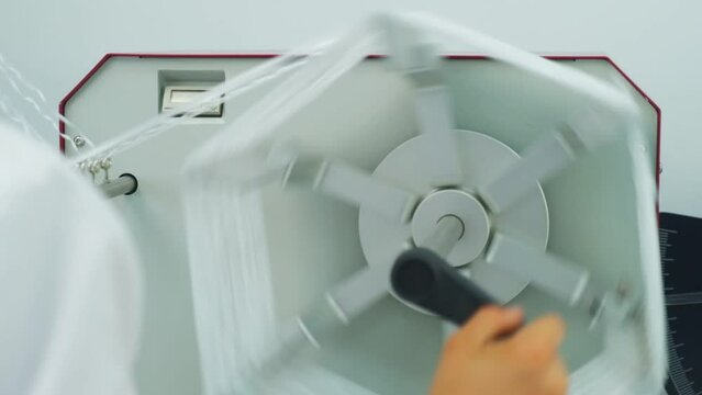 Closeup of polymer thread on the winding wheel in process of winding, slow motion