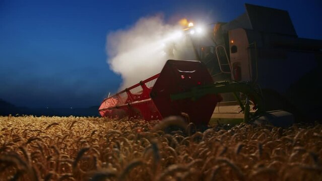 night harvesting with a combine, ukrainian combine harvests wheat, farmers in ukraine. grain export.