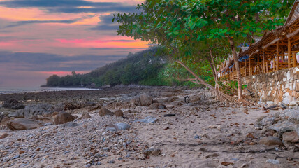 Colourful Skies Sunset over Kalim Beach Patong Pa Tong Beach in Phuket island Thailand. Lovely turquoise blue waters, lush green mountains colourful skies