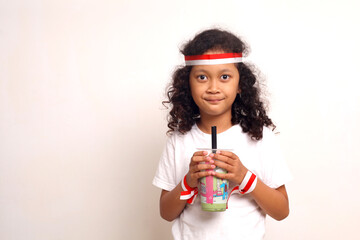 Asian girl standing while holding packaged drinks. Indonesian independence day concept