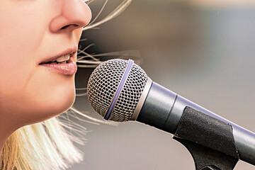 A woman speaks into a microphone during a protest on International Women's Day.