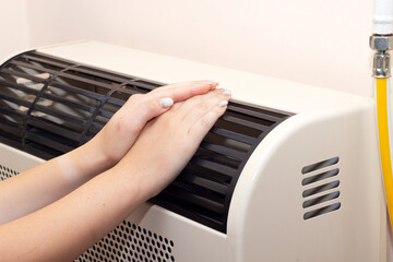 hard hands on the heating radiator, warm hands