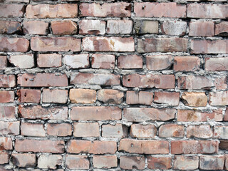 brick red old wall with crumbling bricks and black paint
