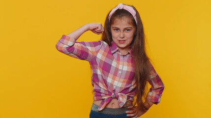 I am strong and independent. Fit sporty young preteen child girl kid showing biceps and looking confident, feeling power strength success win. Little toddler children alone on studio yellow background