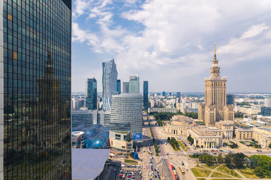 7.22.2022 Warsaw, Poland. The reflection of Palace of Culture and Science on the glass side of Centrum LIM skyscraper. Neomodern buildings vs. social realism. High quality photo