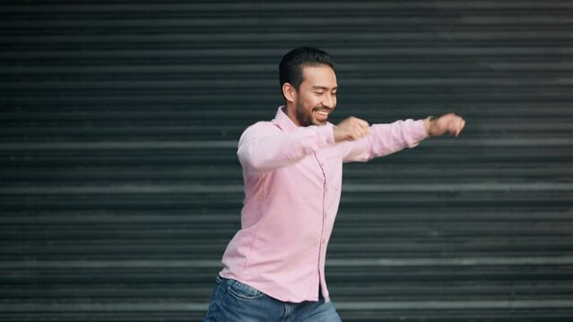 Happy man dancing, feeling excited, carefree and goofy or funny. One young, energetic and joyful male smiling and being silly doing a dance after receiving good news in town alone