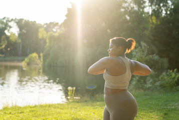 Plus sized African American woman exercising at the park in a summer day