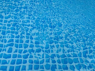 the reflecting water surface with waves in a blue pool