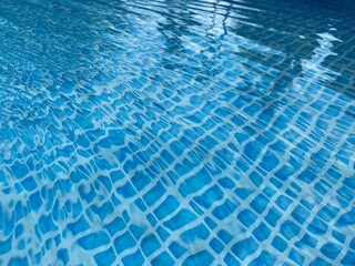 the reflecting water surface with waves in a blue pool