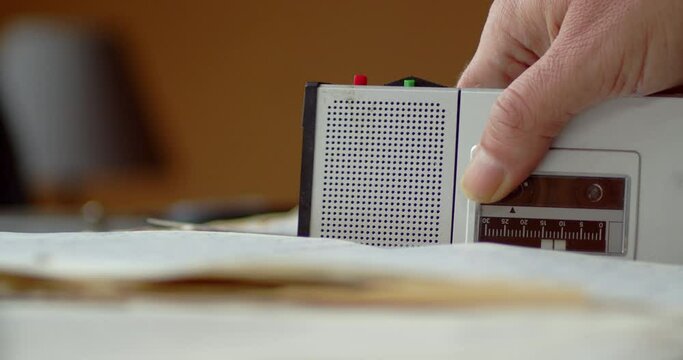 The person places the dictaphone on the documents and presses the red button to record