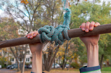 close up of child's hands hold on a bungee