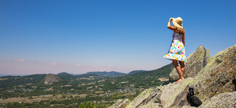 woman on a rock enjoying panoramic view of france vulcano landscape ( volcano suc, Auvergne)