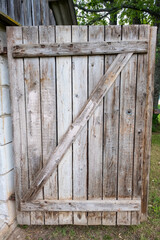 Detail of a open wooden door with big wooden lock in an old shack
