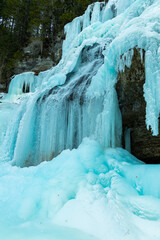 
Winter Scenery: Images from inside the frozen waterfall. It forms a beautiful ice cave, with flowing water and ice stalactites and stalagmites. Sharp details: clear and transparent ice.