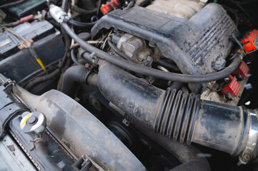 View under the hood of the car. Close-up of a V-shaped six-cylinder old engine. Dirty engine. Time for car maintenance
