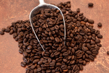 cuillère remplie de grains de café torréfié 