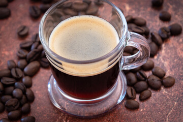 tasse de café et grains  de café sur une table - obrazy, fototapety, plakaty