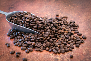 cuillère remplie de grains de café torréfié 