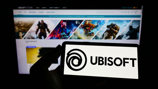 Stuttgart, Germany - 01-06-2022: Person holding cellphone with logo of French video game company Ubisoft Entertainment SA on screen in front of web page. Focus on phone display.
