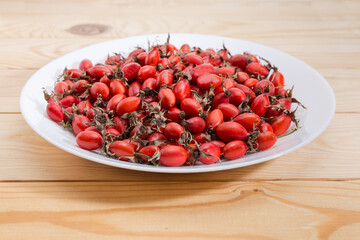 Dry rose hips on dish, close-up in selective focus