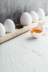 Eggs yolk white raw on grey background