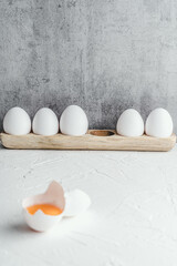 Eggs yolk white raw on grey background