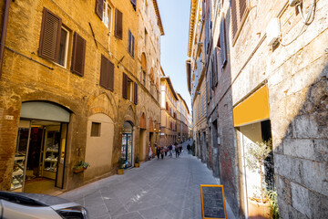 Fototapeta premium View on narrow and cozy street in the old town of Siena city in Italy. Concept of ancient architecture of the Tuscan region