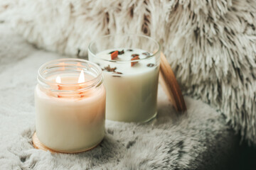 Scented candles in the interior. Interior details in milk colors. Candles in a glass