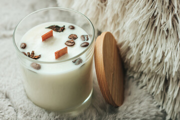 Scented candles in the interior. Interior details in milk colors. Candles in a glass