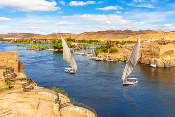 The Nile river scenery and traditional sailboats, Aswan, Egypt - obrazy, fototapety, plakaty