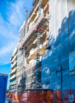 Scaffolding and protection nets on a condominium building affected by facade refurbishment works. Facade bonus tax deductions