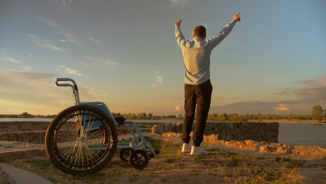 young man in a wheelchair is now on his feet. A young man got rid of his disability.The man recovered from the disease.Against a beautiful sunset