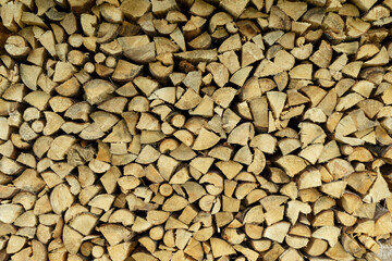 Firewood background. Sawn trunks and logs of needles and birch for making a fire and decor.