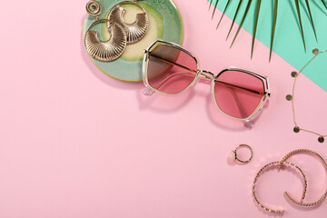 Stylish sunglasses and jewelry on color background, flat lay. Space for text