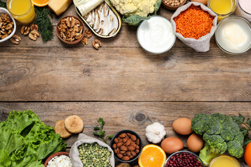 Set of natural food high in calcium on wooden table, flat lay. Space for text