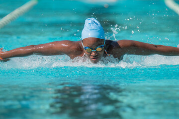 Young woman racing butterfly stroke in a pool