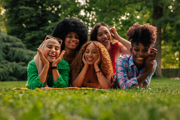 Portrait of diverse women lying on grass