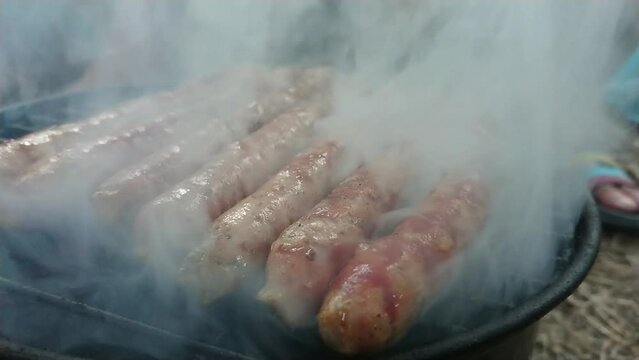 Top side view footage of delicious sausages an toast on hot barbecue.