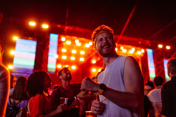 Young man moving to the music with friends at he concert