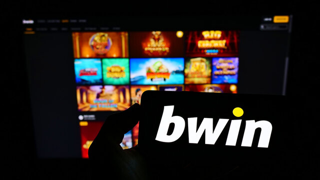 Stuttgart, Germany - 01-08-2022: Person holding cellphone with logo of Austrian company bwin Interactive Entertainment AG on screen in front of webpage. Focus on phone display.