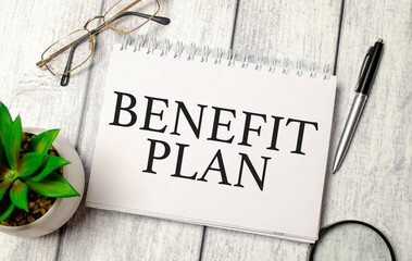 benefit plan words on notepad and pen, calculator and glasses