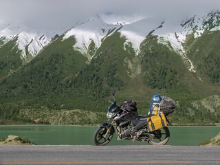 Touring motorcycle and snow covered mountains
