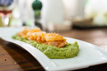 fried prawns on sweet potato puree.