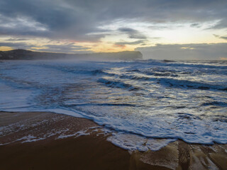 Obraz premium Sunrise at the seaside with large and powerful sets
