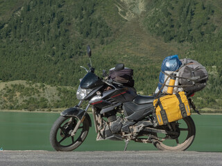 Touring motorcycle in front of turquoise lake